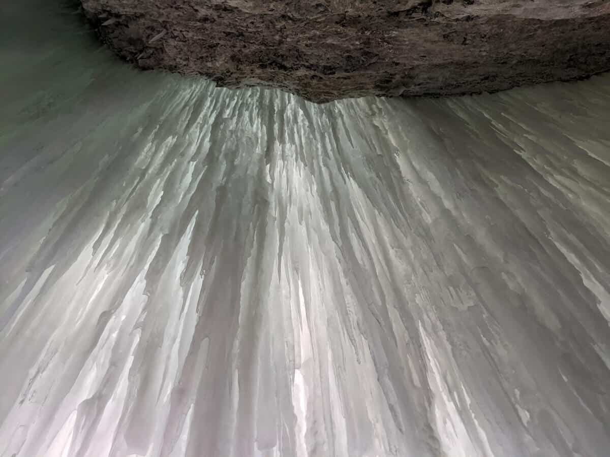 standing behind a frozen waterfall in Jasper National Park