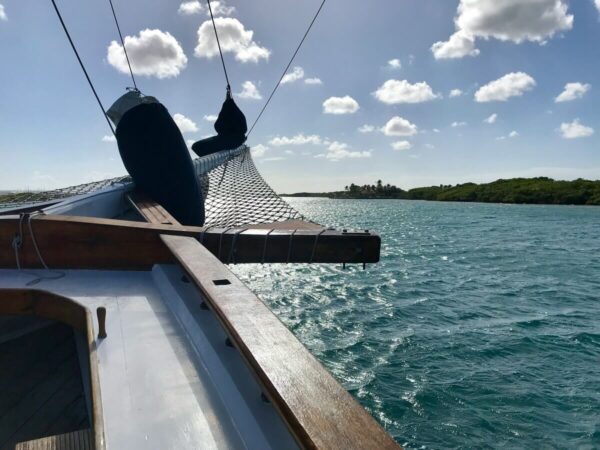 Sailboat's bow cutting through crystal-clear waters on an Aruba snorkel tour